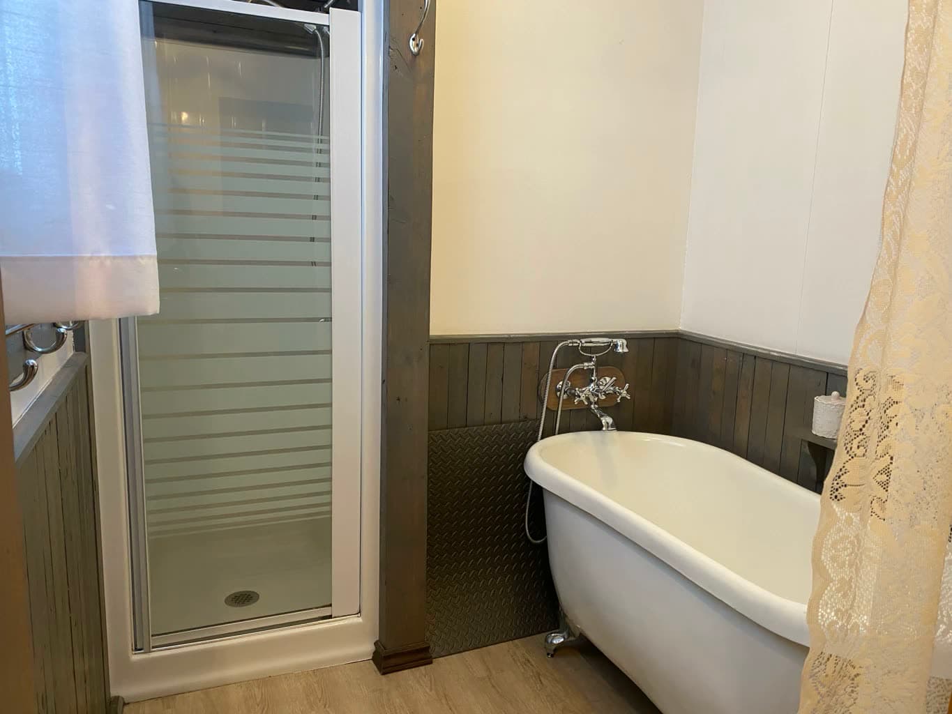 La salle de bain : douche vitrée et baignoire sur pattes.