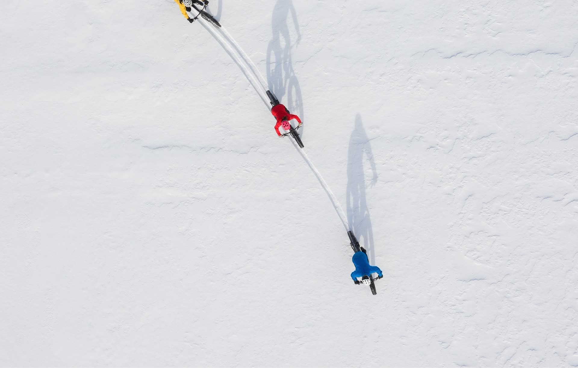 Vue aérienne de deux skieurs de fond traçant leur passage dans la neige.