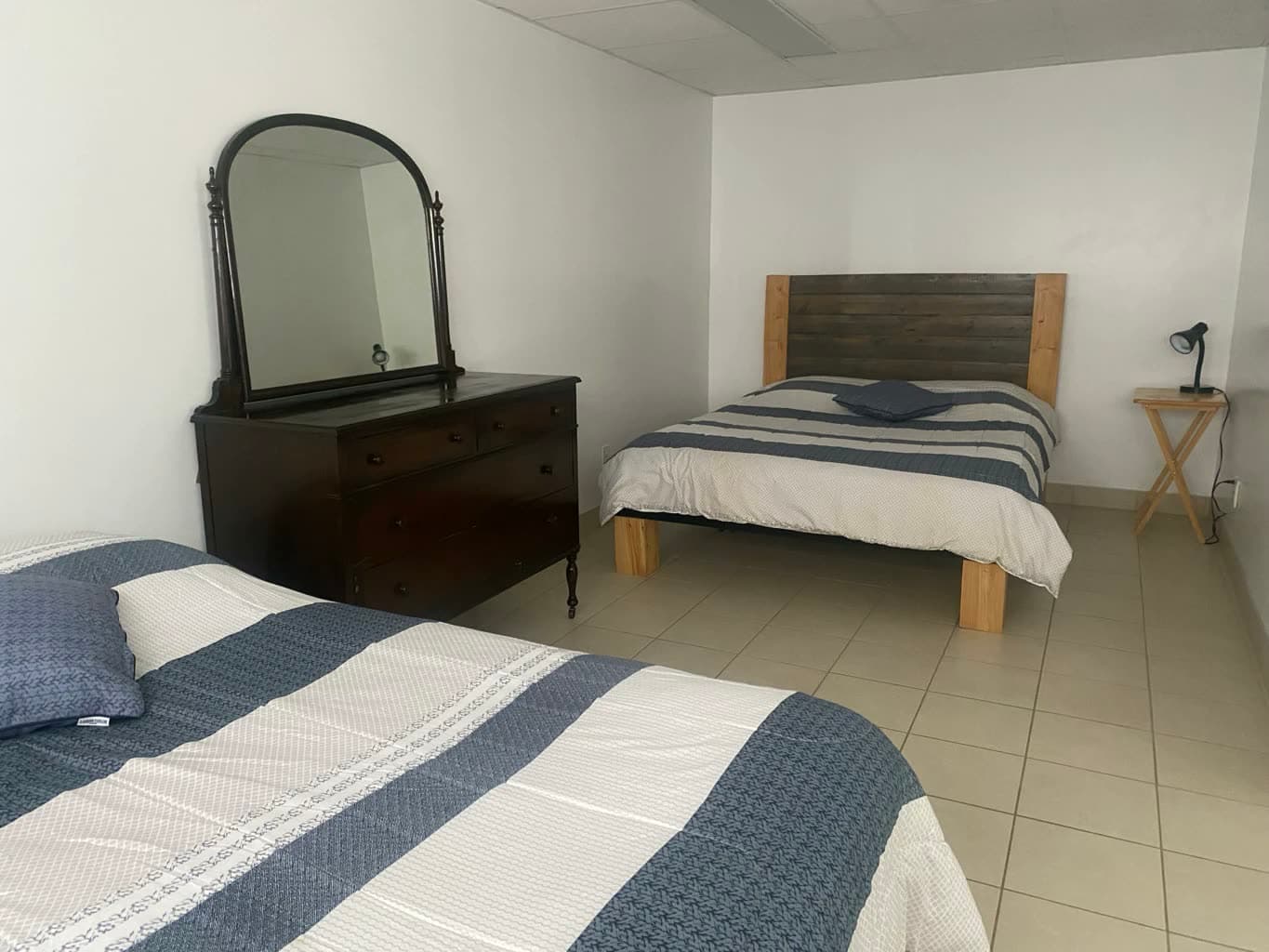 Une chambre, ses lits et sa commode à miroir.