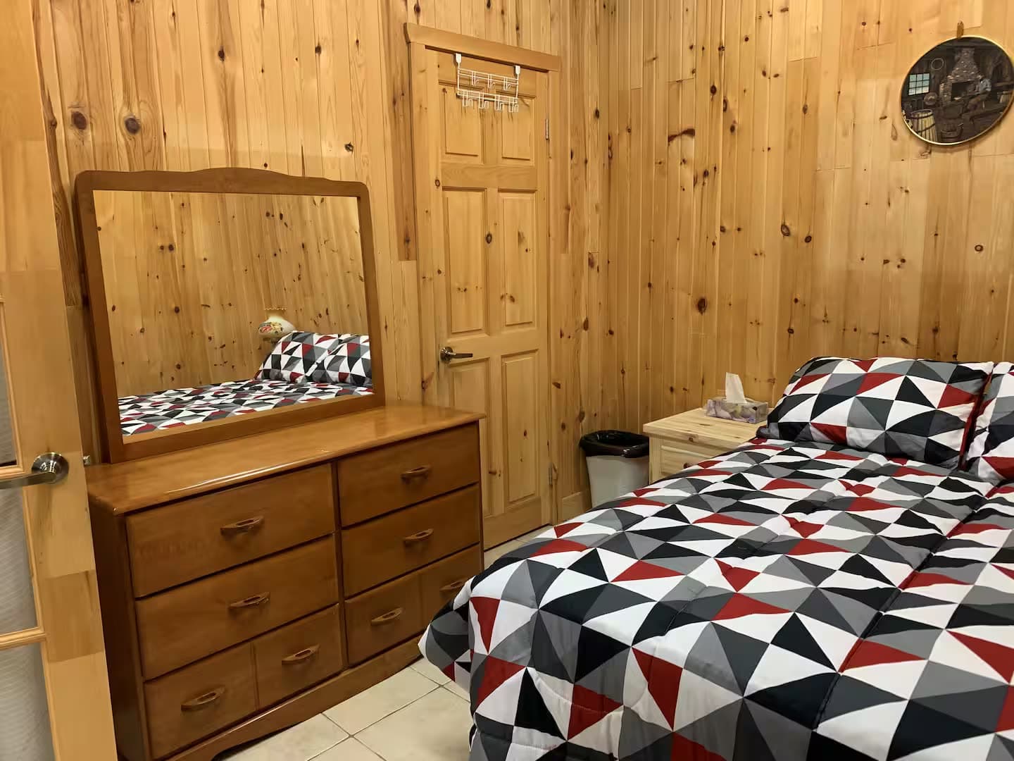 La chambre, son lit double et sa commode à miroir.